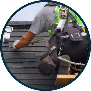 Man repairing damaged shingles on roof